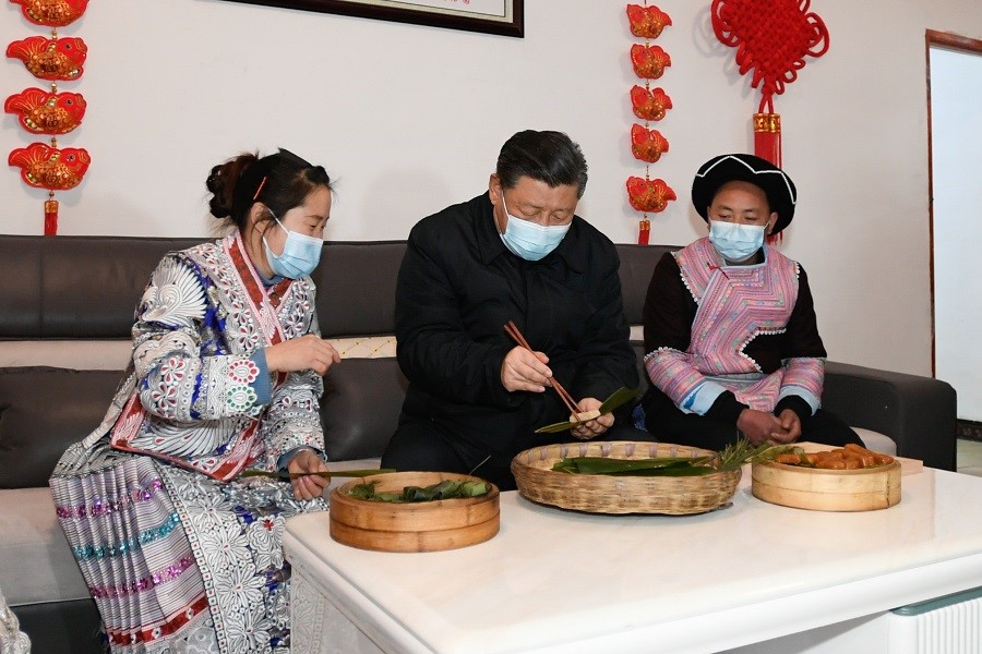2021年2月3日下午，習(xí)近平在貴州畢節(jié)市黔西縣新仁苗族鄉(xiāng)化屋村苗族村民趙玉學(xué)家，同一家人邊聊家常邊制作當(dāng)?shù)貍鹘y(tǒng)節(jié)日食品黃粑。新華社記者 李學(xué)仁 攝